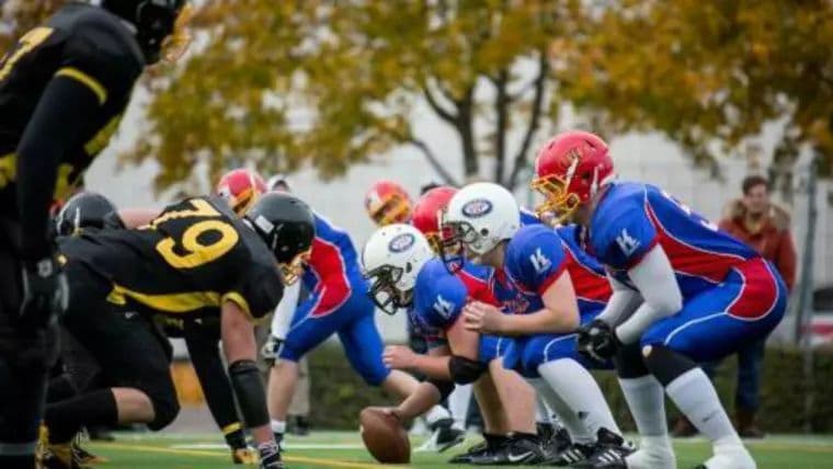 Amerikansk fotball der to lag ligger klare på angrepslinjen før utspill.
