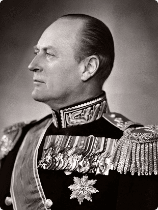 Sort-hvitt portrett av en mann i uniform med ordener og medaljer, i profil.
