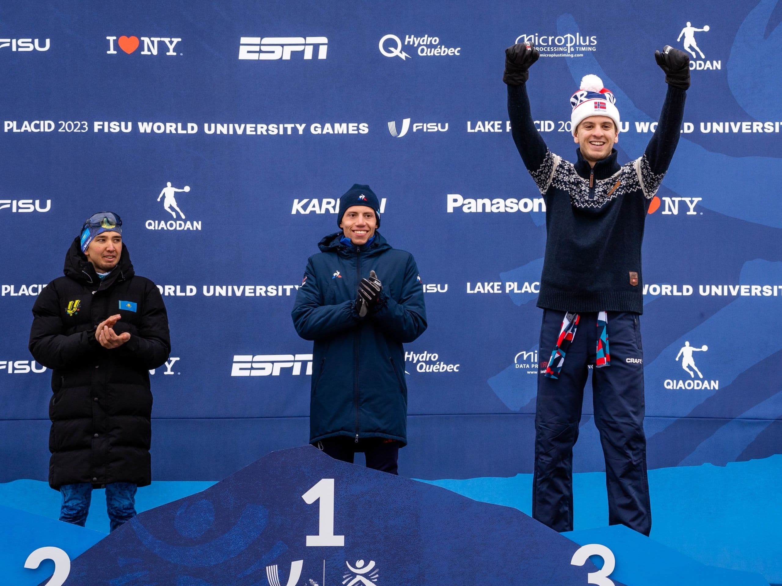 En norsk utøver jubler på øverste trinn av seierspallen under FISU World University Games i Lake Placid 2023.