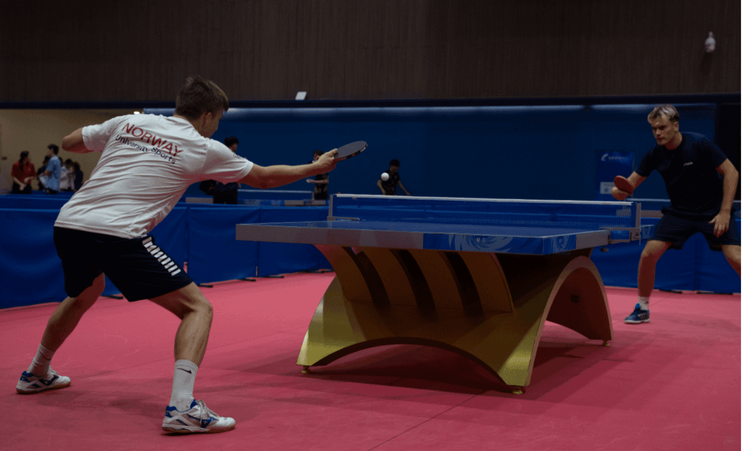 To spillere i aksjon under en bordtenniskamp.