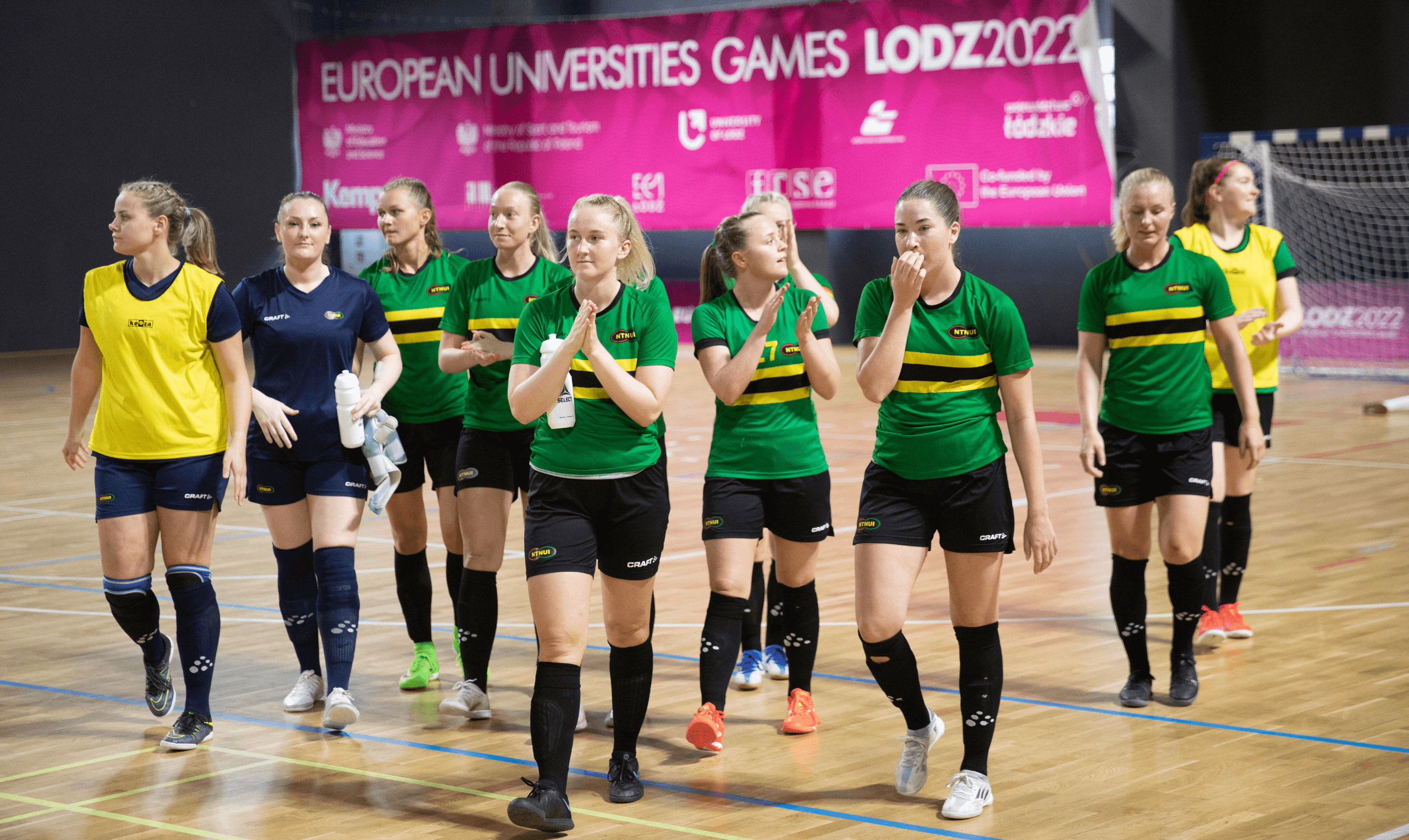 Kvinnelig futsallag i grønne drakter går inn på banen under European Universities Games Lodz 2022.