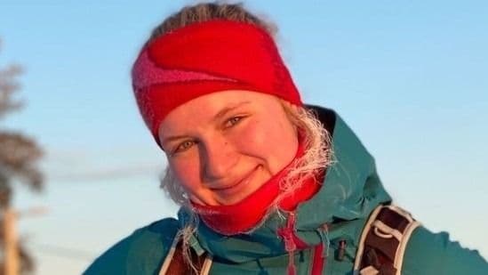 Portrett av en kvinne med rødt pannebånd og turjakke i vintersol.